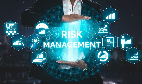 A man in business attire surrounded by icons of charts and presentations. The words 'risk management' are in front of him.